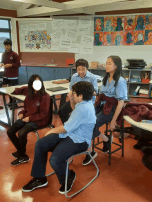 a group of children are sitting in a classroom with a sign that says essential questions