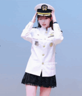 a girl in a military uniform salutes while another girl walks by