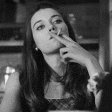 a black and white photo of a woman smoking