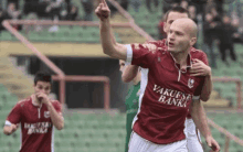 a man wearing a burgundy and white soccer jersey that says vakufska banka