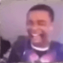 a blurry picture of a man laughing while sitting in front of a computer screen .