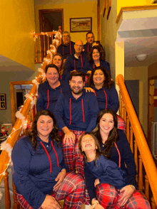 a family posing for a picture on the stairs wearing pajamas