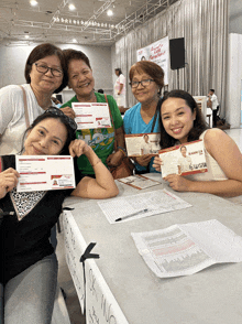 a group of women sitting at a table with a sign that says ok inno