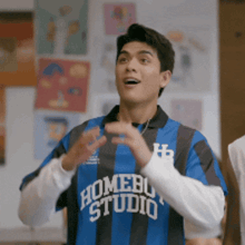 a man wearing a blue and black striped shirt that says home studio on it