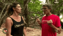 a man wearing a red givova t-shirt talks to a woman