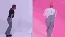 a woman and a man are dancing on a pink floor .