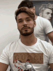 a man with a beard wears a gucci t-shirt