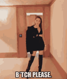 a woman in a black dress and thigh high boots is standing in a hallway with the words b * tch please above her