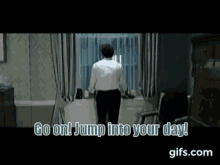 a man in a white shirt and black pants is standing in a room with the words go on jump into your day .