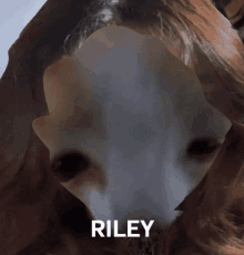 a close up of a person 's face with the name riley written below it