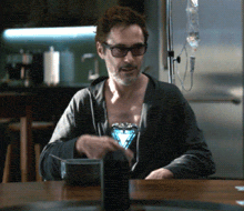 a man is sitting at a table with an iv in his arm