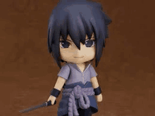 a figurine of sasuke uchiha from naruto with a sword in his hand .