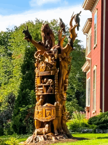 a large statue of animals is in front of a large red house