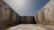 a large empty room with a brick wall and a blue sky in the background