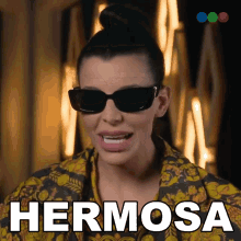 a woman wearing sunglasses has the word hermosa above her head