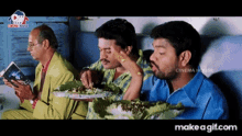 a group of men are sitting around a table with plates of food and a sign that says cinema house