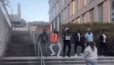 a group of people are dancing on the stairs and one of them has the number 22 on his back