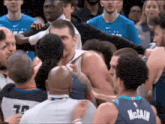 a basketball player in a mccain jersey is surrounded by other players