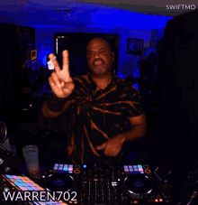 a dj named warren702 is giving a peace sign in front of a mixer