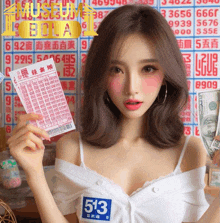 a woman holding a ticket with the number 513 on her chest