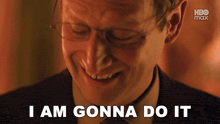 a man with glasses is smiling with the words i am gonna do it below him
