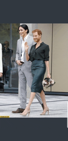 a man in a suit and a woman in a pencil skirt are walking down the street