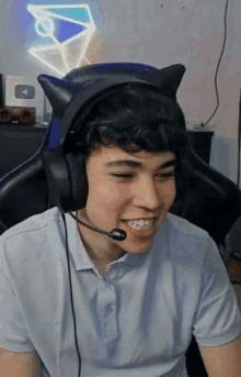 a young man is wearing headphones and a microphone while sitting in a chair .