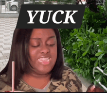 a woman drinking from a straw with a sign that says yuck over her head