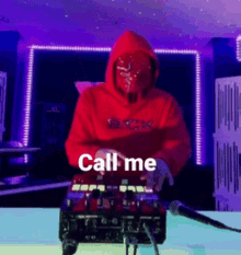 a man in a red hoodie is playing a mixer and the words call me are on the screen behind him