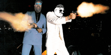 a man in a blue suit and a man in a white suit shooting guns