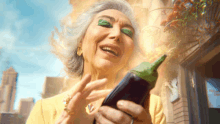 an elderly woman with green eye shadow is holding a large eggplant