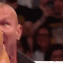 a close up of a man 's face with a crowd behind him .