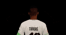 a man wearing a white shirt with the name traore on it