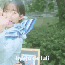 a girl is holding a striped umbrella and the words hyeju de luli are on the bottom