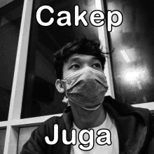 a black and white photo of a man wearing a mask with the words cakep juga above him