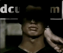 a man 's face is covered by a sign that says dcu on it