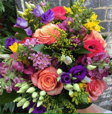 a bouquet of colorful flowers including pink and purple roses and yellow flowers