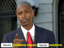 a man in a suit and tie is pointing at the camera with the words marko problems require marko solutions below him