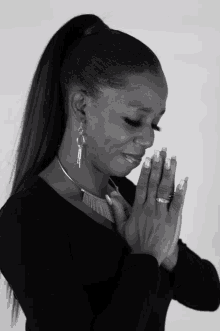 a black and white photo of a woman praying