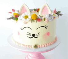 a cake with a cat face and flowers on top