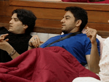a man in a blue shirt is laying in a bed