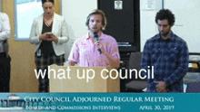 a man stands at a podium with a microphone and the words what up council on the bottom