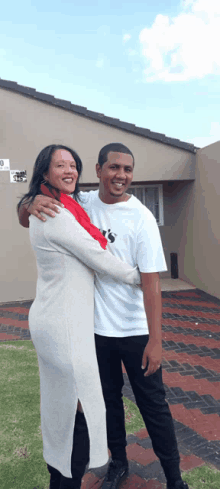 a man and woman are posing for a picture in front of a building