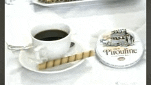 a cup of coffee is sitting on a saucer next to a can of piroline .