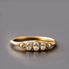 a gold ring with three oval shaped diamonds