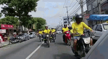 a group of people are riding motorcycles down a street in front of a sign that says ' loterias ' on it