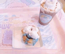 a cinnamon roll and a cup of coffee on a pink tray .