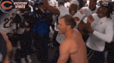 a man without a shirt is surrounded by a group of players and a banner that says victory vibes