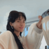 a woman in a white sweater is holding a bowl in her hands