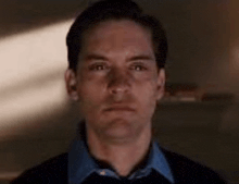 a close up of a man 's face in a dark room looking at the camera .